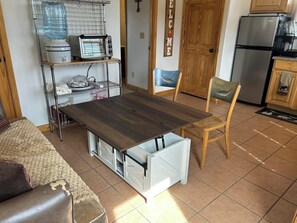 A compact kitchen with a built-in microwave, a water dispenser, and a refrigerator.