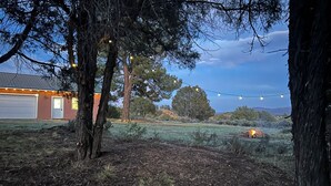 Una proprietà residenziale con garage, alberi e luci a stringa.