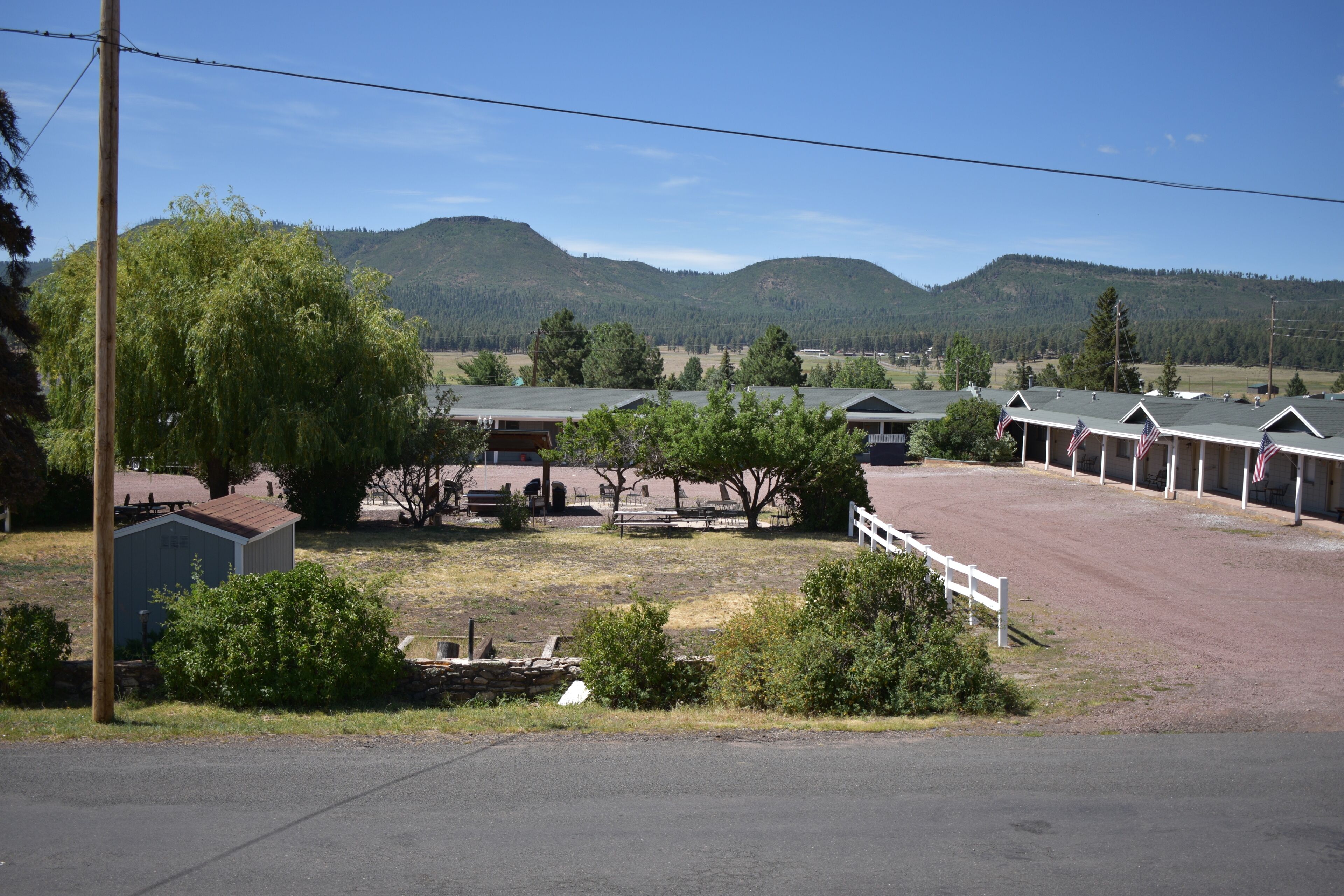 Un motel doté de nombreuses chambres, d’un parking et situé au pied de montagnes.