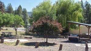 A picnic area with tables and chairs, a barbecue grill, and a covered pavilion.