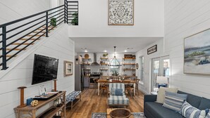 A spacious living area with a staircase, a dining area, and a kitchen.