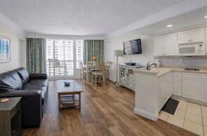 Un apartamento moderno con sala de estar, comedor, cocina y balcón.