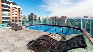 A rooftop pool with lounge chairs, a clear sky, and a cityscape in the background. - RCT Hospedagens - Perdizes Palestra Itália (São Paulo)