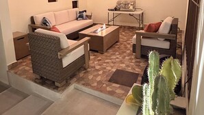 Ein gemütlicher Wohnbereich mit einer Couch, einem Couchtisch und einer Säulencactus-Pflanze.