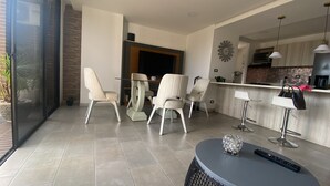 Eine moderne Küche mit Essbereich, einem runden Tisch und Barhocker.