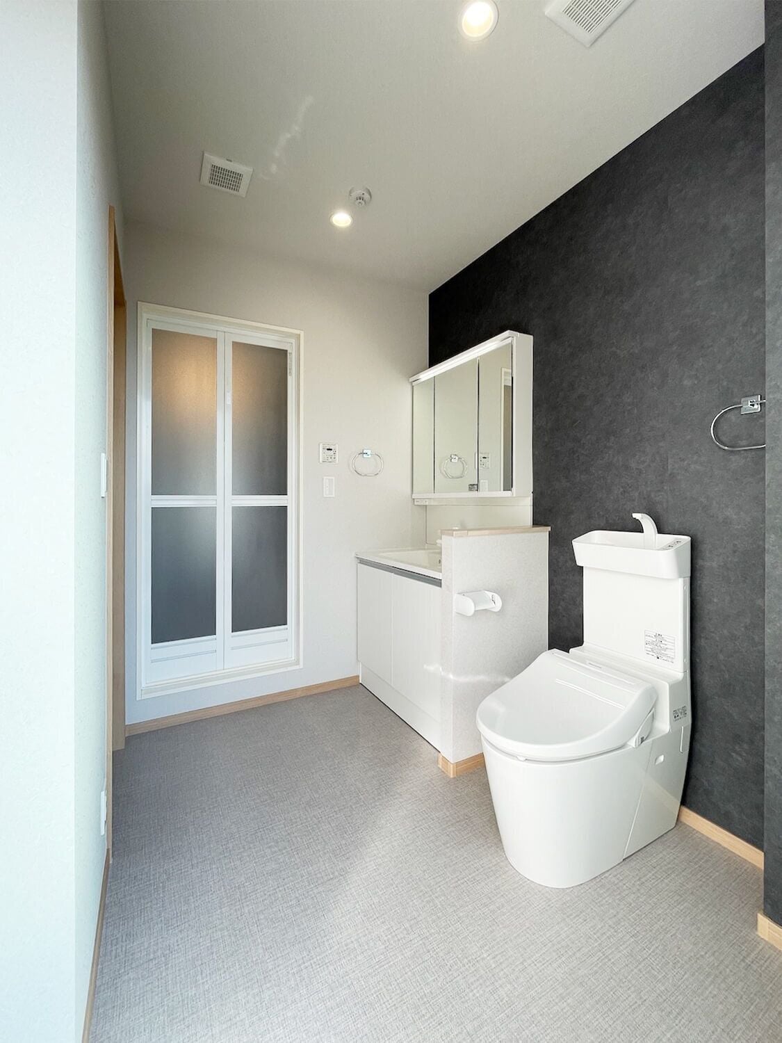 A modern bathroom with a toilet, bidet, and a mirror.