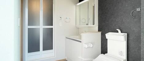 A modern bathroom with a toilet, bidet, and a mirror.