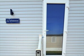 A residential building with a blue door, a security camera, and a sign indicating 'STONEWOOD VICTORY 41-3 BEDROOM.' - 3-Bed - Sleeps 6 - Parking - Balcony (Malton)
