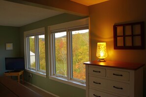 A room with a large window, a desk with a computer, a lamp, and a cabinet. - Cozy mountain condo on family run ski resort, hiking, biking and more.  (Richmond)