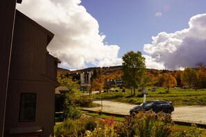 Ein Wohngebiet mit Parkplatz, Häusern und einem Berg im Hintergrund.