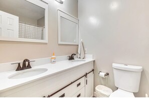 A bathroom with a white sink, a mirror, a toilet, and a towel rack. - Cozy mountain condo on family run ski resort, hiking, biking and more.  (Richmond)