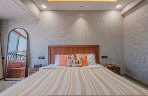Ein modernes Schlafzimmer mit einem großen Bett, einem Holz-Kopfteil und Blick durch einen großen Spiegel.