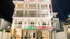 Un hôtel à plusieurs étages, reconnaissable à son enseigne bien visible indiquant « PHUONG THUY HOTEL » et à sa devanture où l’on peut lire « ANT STORE ».