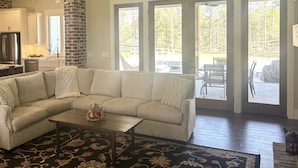 A living room with a sectional sofa, a coffee table, and a patterned rug.