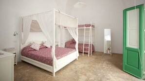 A bedroom with a canopy bed, a bunk bed, a ladder, a nightstand, and a green door. - Relais of Hearts with terrace (Matino)