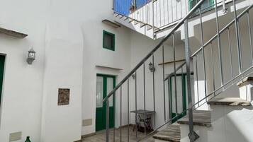 Un edificio bianco con una scala che conduce a un balcone.