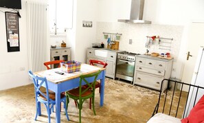 Une cuisine équipée d’une table à manger, de chaises, d’une cuisinière et d’un réfrigérateur.