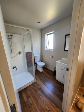 Un baño con ducha, inodoro y lavabo.