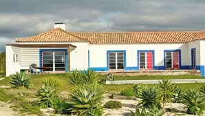 Una casa de dos pisos con techo de tejas, garaje y porche delantero.