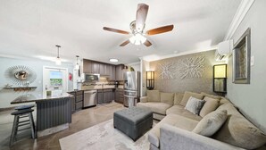 A modern kitchen with a central island, stainless steel appliances, and a ceiling fan. - Tipsy Turtle -2 bed 3 bth Condo with Pool/ Dockage at Marina and gorgeous Gulf water views (Marathon)