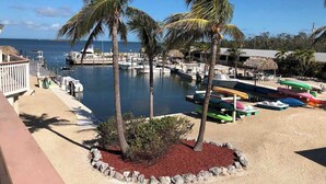 A marina with boats, palm trees, and a view of the sea. - Tipsy Turtle -2 bed 3 bth Condo with Pool/ Dockage at Marina and gorgeous Gulf water views (Marathon)