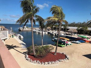 A marina with boats, palm trees, and a view of the sea. - Tipsy Turtle -2 bed 3 bth Condo with Pool/ Dockage at Marina and gorgeous Gulf water views (Marathon)