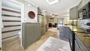 A modern kitchen with grey cabinets, a microwave, and a ceiling fan. - Tipsy Turtle -2 bed 3 bth Condo with Pool/ Dockage at Marina and gorgeous Gulf water views (Marathon)