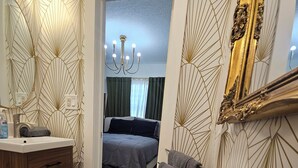 A bathroom with a sink, mirror, towel rack, and a trash can. - Charming  Studio Apartment 1 in Fort Lauderdale.  (Fort Lauderdale)
