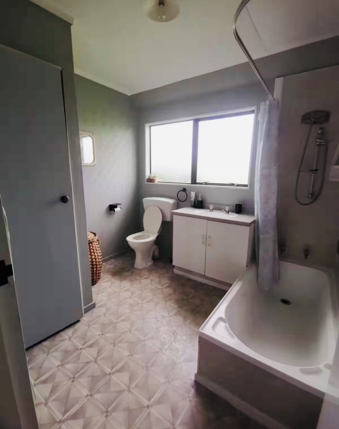 Baño con inodoro, lavabo, ducha y ventana.