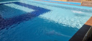 A swimming pool with clear water and a tiled edge.