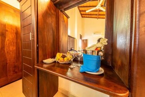 A wooden interior with a counter, a basket of fruit, wine glasses, and a metal container. - Owinmo Hotel & Reception Hall (Uluwitike, Galle)