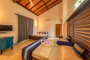 Un dormitorio con cama, televisión, ventana con cortinas y techo de madera.