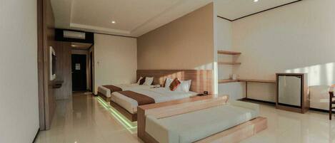 Una habitación de hotel moderna con una cama grande, una mesita de noche, un escritorio pequeño y una zona de estar.