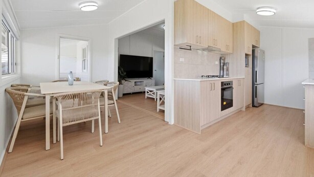 A modern kitchen with light wood cabinets, a built-in oven, and a refrigerator. - Central Coast Waterfront | 2BR + Jetty Access (Koolewong)