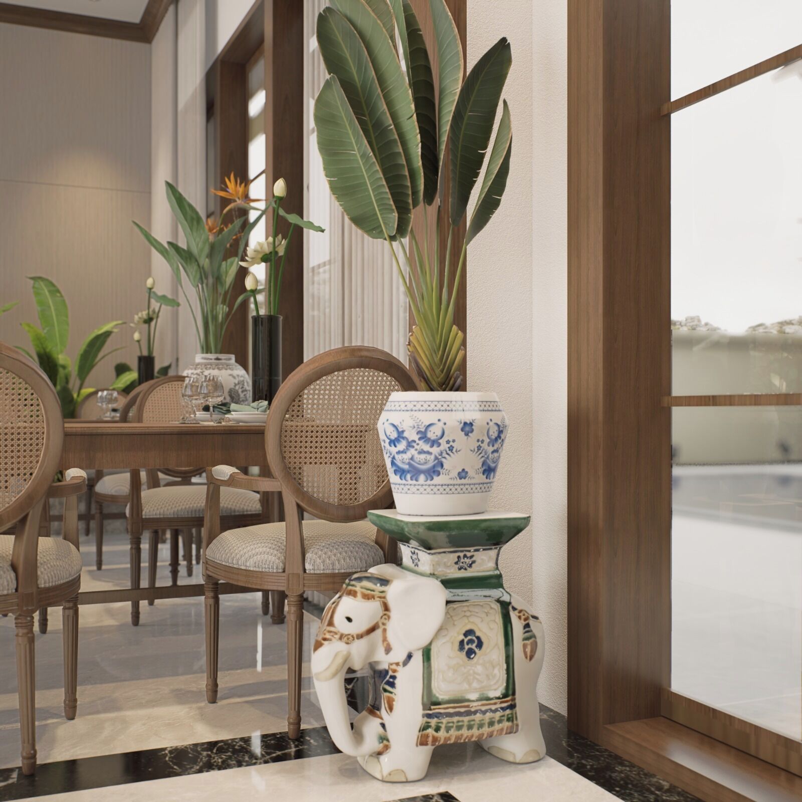 Un espace repas comprenant une table, des chaises et des éléments de décoration, notamment une grande plante, un vase avec des fleurs et un éléphant en céramique.