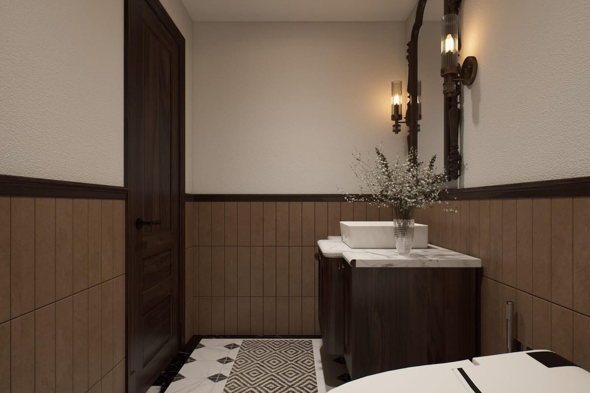 Une salle de bain avec une porte en bois, un lavabo blanc orné d’un vase de fleurs et un luminaire fixé au mur.