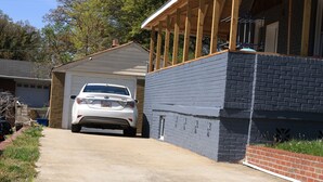 Een huis met garage, overdekte veranda en oprit.