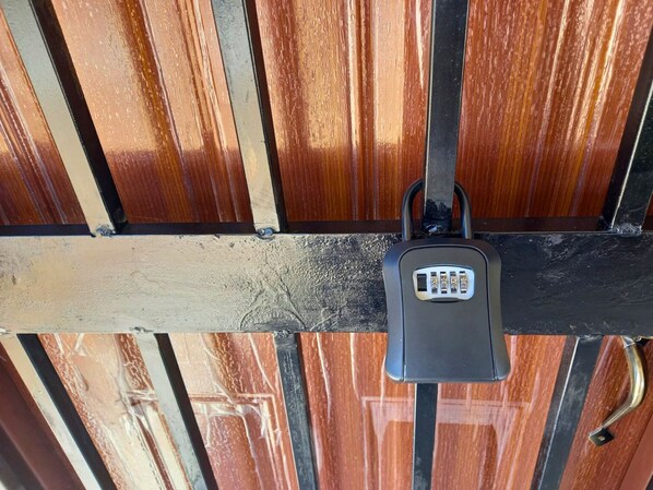 A metal gate with a keypad lock.