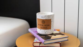 Una mesa redonda con una taza de cerámica blanca con el rótulo 'Nordic Sense Home Made Spa' y dos libros apilados encima.