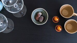Vue plongeante d’une table à manger, avec différents types de verres et de plats en céramique.