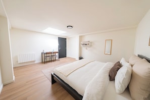 Quarto com uma cama, uma escrivaninha e uma cadeira.