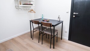 A small room with a table and two chairs, a white shelf with a few items, and a black door. - Relaxing 2 Private Rooms Close to Center (Ghent)