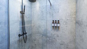A shower area with a glass door, a handheld showerhead, and three bottles of shampoo on the wall. - Relaxing 2 Private Rooms Close to Center (Ghent)