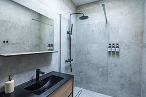 A modern bathroom with a black sink, a glass-enclosed shower, and a large mirror. - Cozy 3 Private Rooms Near to City Center (Ghent)
