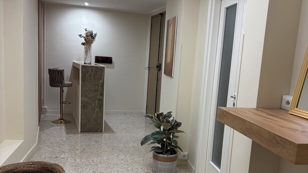 A hallway with a skylight, a potted plant, a woven basket, and a marble floor. - Rooms Duepuntozero  (Reggio Calabria)