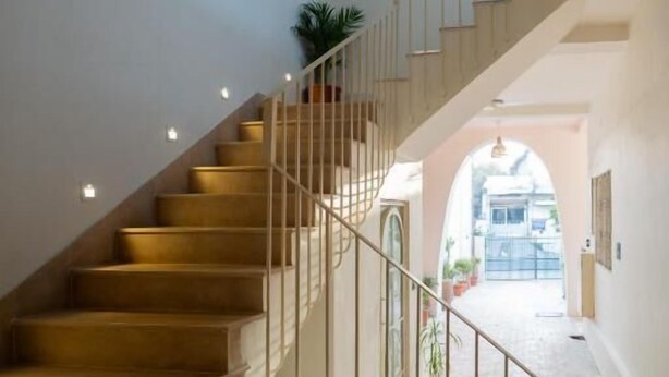 Una escalera de madera con barandales de metal que conduce a un piso superior.
