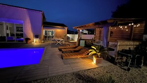 A pool area with lounge chairs, a table, and a wooden deck. - Spacious, bright, fully renovated villa in an excellent location. (Istres)