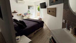 A modern bedroom with a bed, bedside table, and a large mirror. - Spacious, bright, fully renovated villa in an excellent location. (Istres)