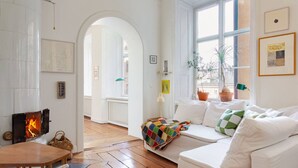 Ein gemütliches Wohnzimmer mit Kamin, einer Couch, einem Couchtisch und Blick durch ein Fenster.