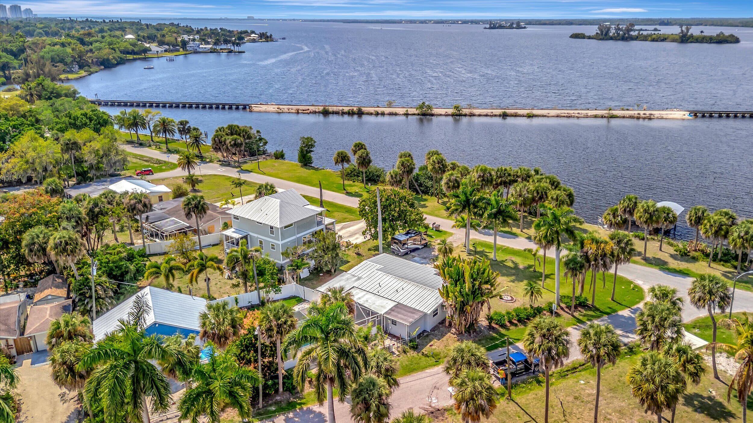 A coastal residential area with houses, palm trees, and a marina.